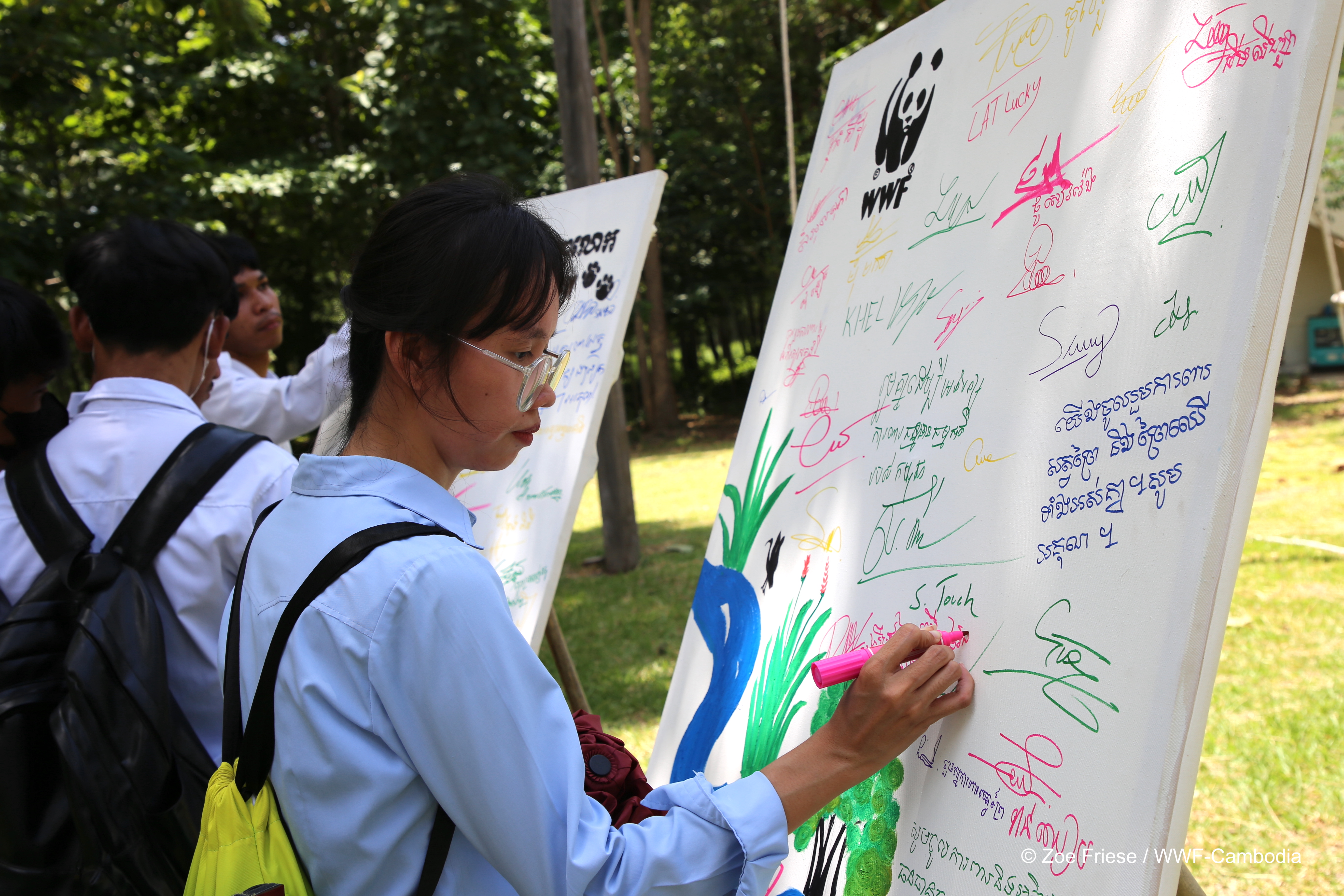 Event participants sign a pledge board committing to protect Asian elephants and their forest habitat.